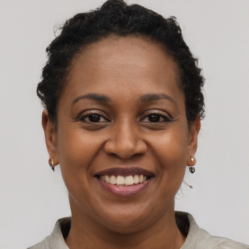 Joyful black young-adult female with short  brown hair and brown eyes