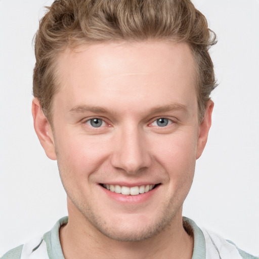 Joyful white young-adult male with short  brown hair and blue eyes