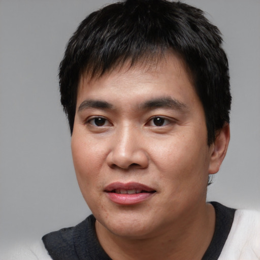 Joyful asian young-adult male with short  black hair and brown eyes