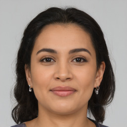 Joyful latino young-adult female with medium  brown hair and brown eyes