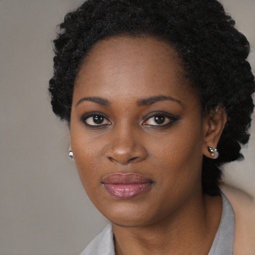 Joyful black young-adult female with long  black hair and brown eyes