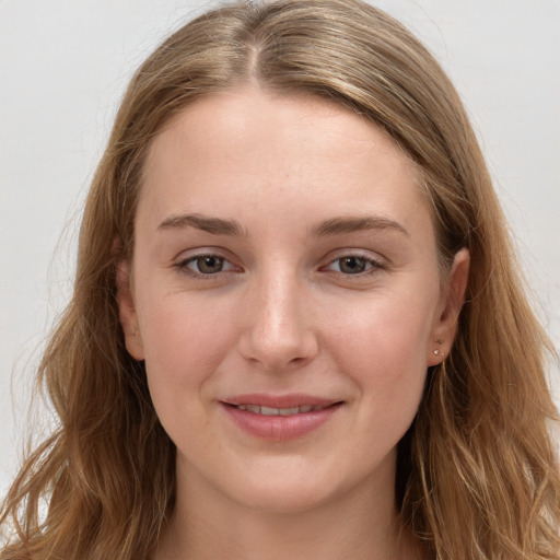 Joyful white young-adult female with long  brown hair and grey eyes