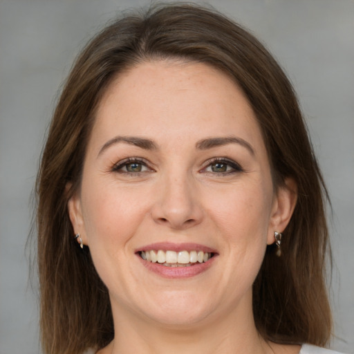 Joyful white adult female with medium  brown hair and green eyes