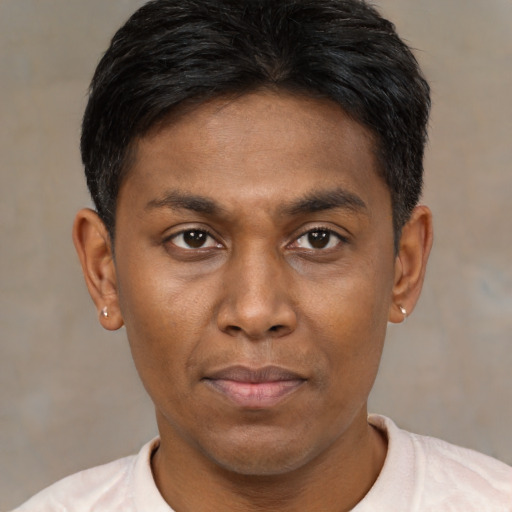 Joyful black young-adult male with short  brown hair and brown eyes