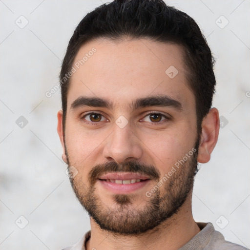 Joyful white young-adult male with short  black hair and brown eyes