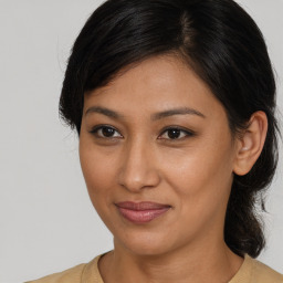 Joyful latino young-adult female with medium  brown hair and brown eyes