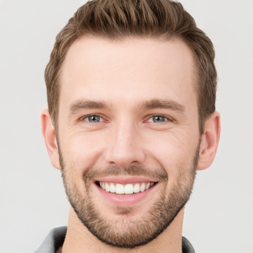 Joyful white young-adult male with short  brown hair and grey eyes