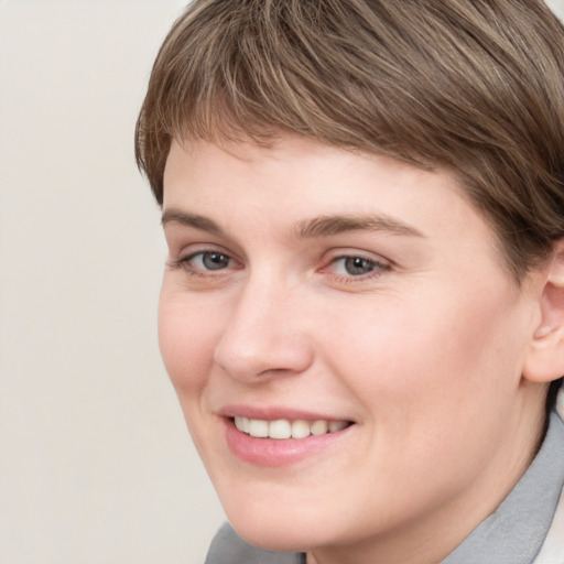 Joyful white young-adult female with short  brown hair and grey eyes