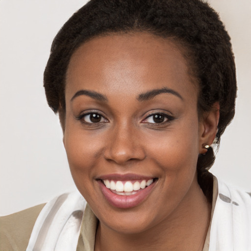 Joyful black young-adult female with short  brown hair and brown eyes