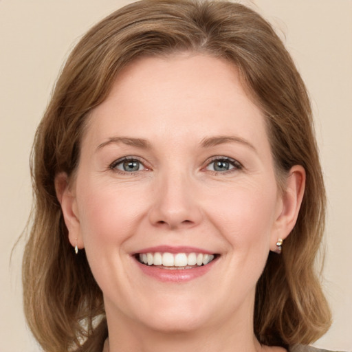 Joyful white adult female with medium  brown hair and green eyes