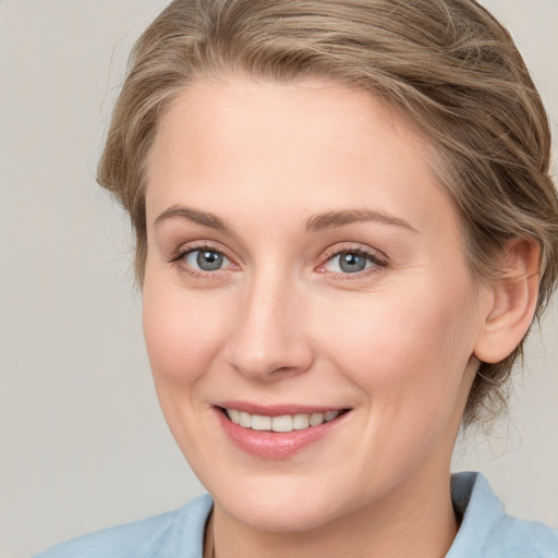 Joyful white young-adult female with medium  brown hair and blue eyes