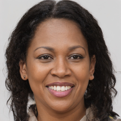 Joyful black adult female with long  brown hair and brown eyes