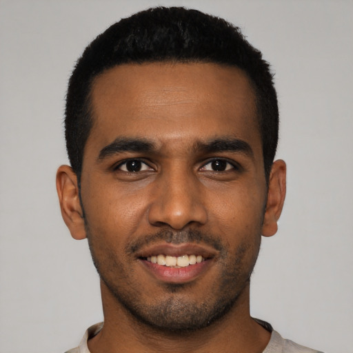 Joyful black young-adult male with short  black hair and brown eyes