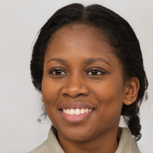 Joyful black adult female with medium  brown hair and brown eyes