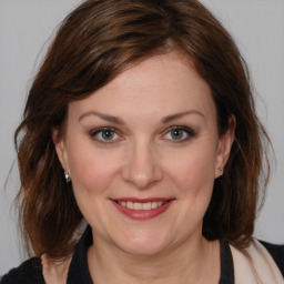 Joyful white adult female with medium  brown hair and brown eyes