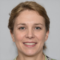 Joyful white adult female with medium  brown hair and grey eyes