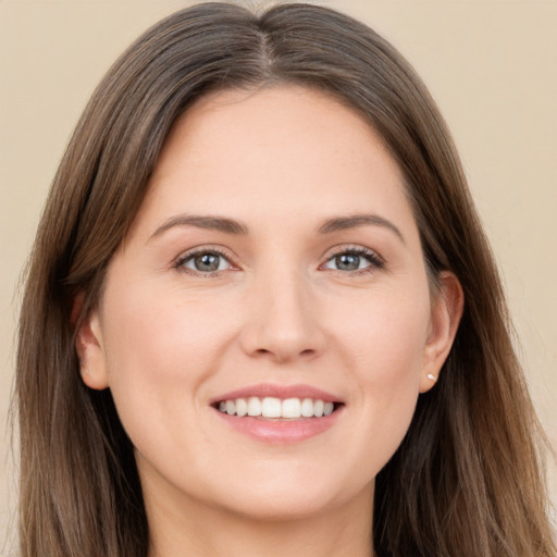 Joyful white young-adult female with long  brown hair and brown eyes