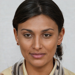 Joyful latino young-adult female with medium  brown hair and brown eyes