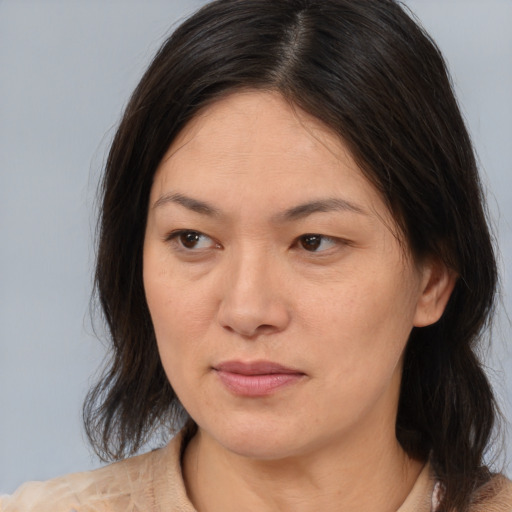 Joyful asian adult female with medium  brown hair and brown eyes