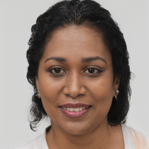 Joyful black adult female with long  brown hair and brown eyes