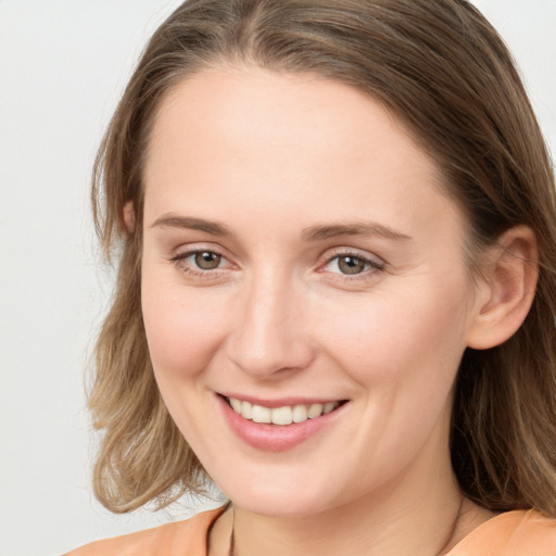 Joyful white young-adult female with medium  brown hair and blue eyes