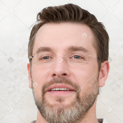 Joyful white young-adult male with short  brown hair and grey eyes