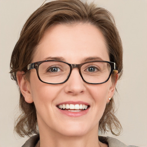 Joyful white adult female with medium  brown hair and blue eyes