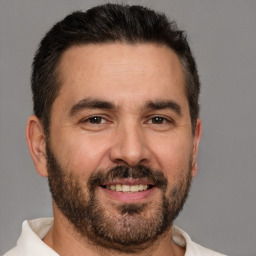 Joyful white adult male with short  brown hair and brown eyes