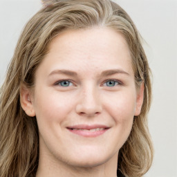 Joyful white young-adult female with long  brown hair and blue eyes