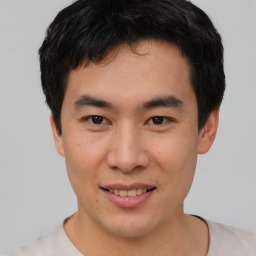 Joyful asian young-adult male with short  brown hair and brown eyes