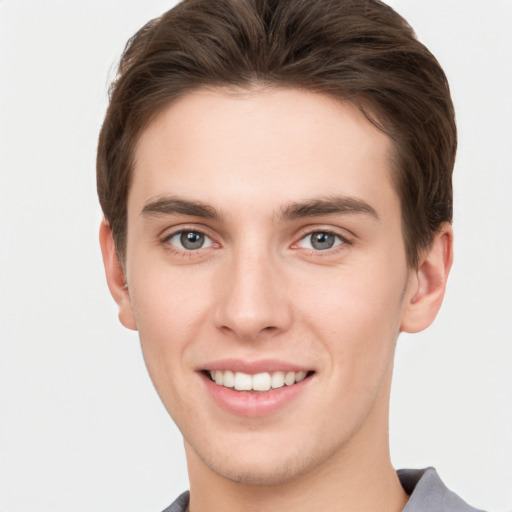 Joyful white young-adult male with short  brown hair and grey eyes