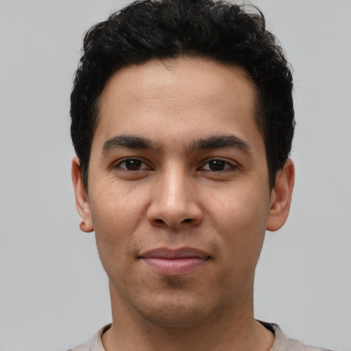 Joyful latino young-adult male with short  black hair and brown eyes