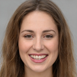 Joyful white young-adult female with long  brown hair and green eyes