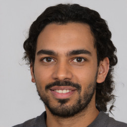 Joyful latino young-adult male with short  black hair and brown eyes