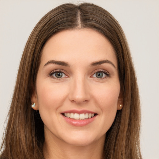 Joyful white young-adult female with long  brown hair and green eyes