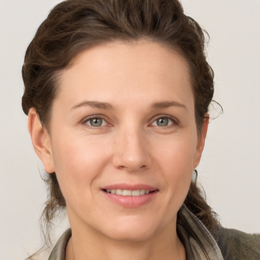 Joyful white adult female with medium  brown hair and grey eyes