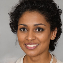 Joyful black young-adult female with medium  brown hair and brown eyes