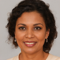 Joyful black adult female with medium  brown hair and brown eyes