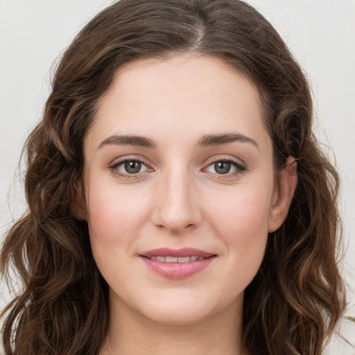 Joyful white young-adult female with long  brown hair and green eyes