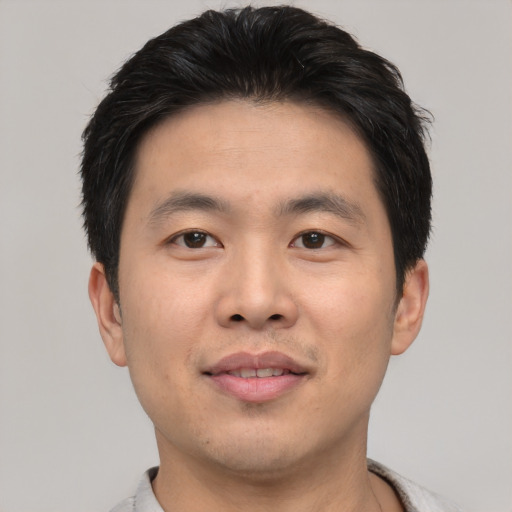 Joyful asian young-adult male with short  black hair and brown eyes