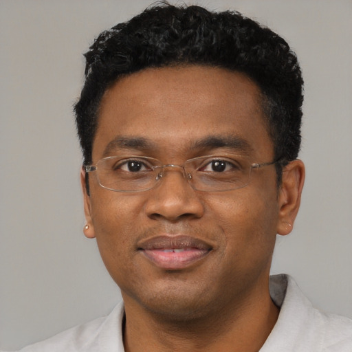 Joyful black young-adult male with short  black hair and brown eyes