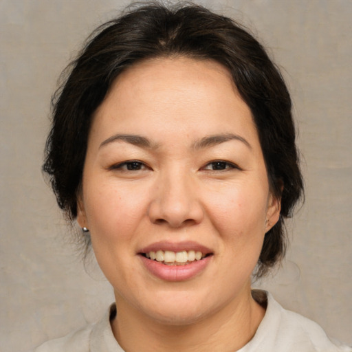 Joyful asian adult female with medium  brown hair and brown eyes