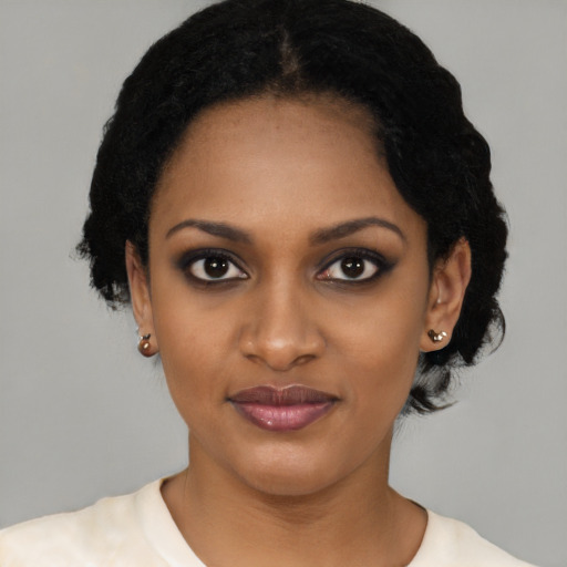 Joyful black young-adult female with short  black hair and brown eyes