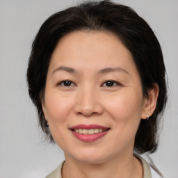 Joyful white adult female with medium  brown hair and brown eyes