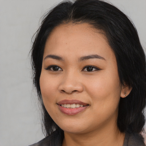 Joyful asian young-adult female with long  black hair and brown eyes