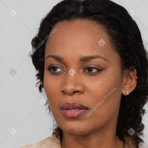 Joyful black young-adult female with long  black hair and brown eyes