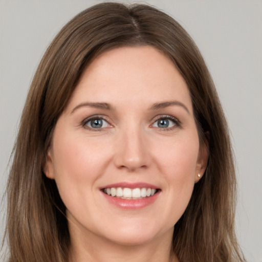 Joyful white young-adult female with long  brown hair and grey eyes