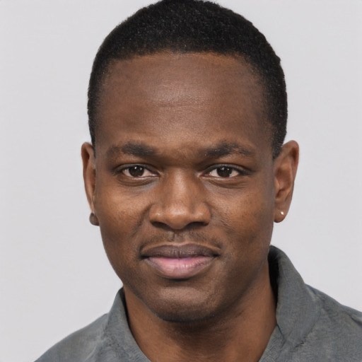 Joyful black young-adult male with short  black hair and brown eyes
