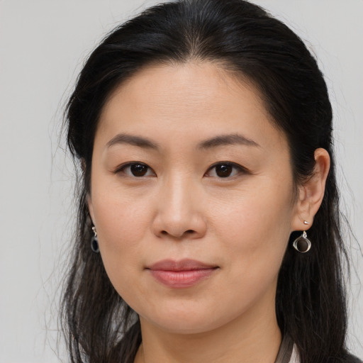 Joyful asian young-adult female with long  brown hair and brown eyes