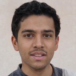 Joyful latino young-adult male with short  brown hair and brown eyes